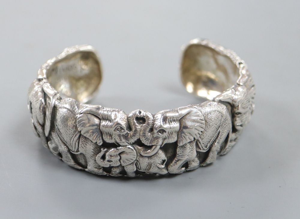 A modern white metal bangle modelled as a heard of elephants by Patrick Mavros,